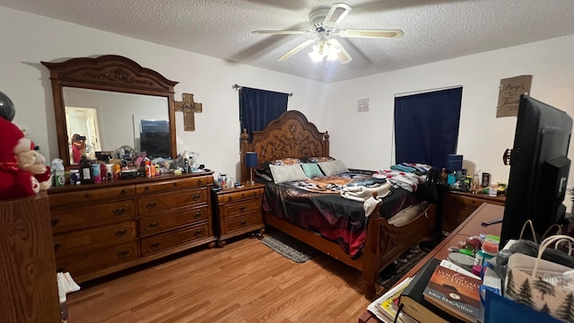 bedroom with a textured ceiling, light hardwood / wood-style floors, and ceiling fan