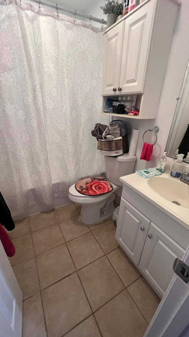 bathroom featuring vanity, curtained shower, tile patterned floors, and toilet