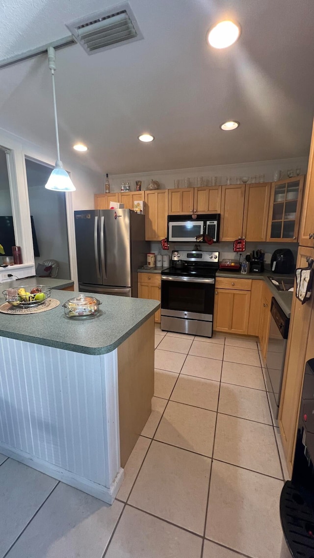 kitchen featuring light tile patterned floors, pendant lighting, and appliances with stainless steel finishes