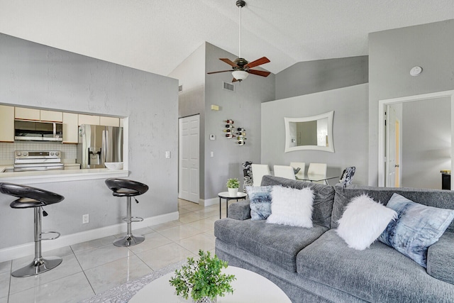 living room with ceiling fan, high vaulted ceiling, and light tile patterned floors