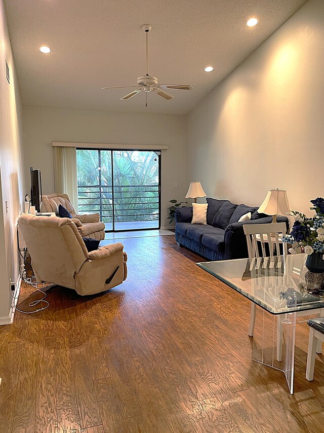 living room featuring hardwood / wood-style floors, a textured ceiling, and ceiling fan