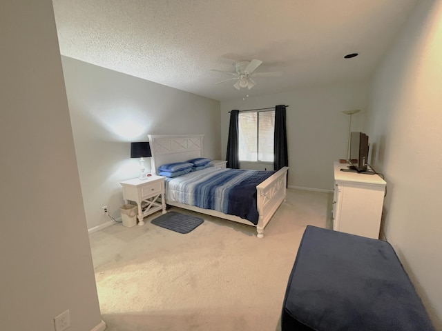 bedroom with a textured ceiling, light colored carpet, and ceiling fan