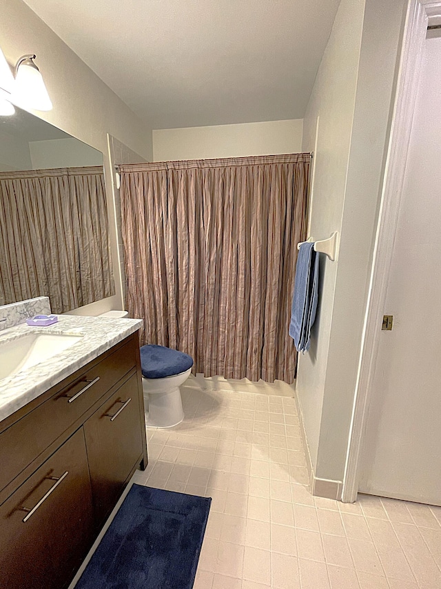 bathroom with toilet, vanity, and tile patterned floors