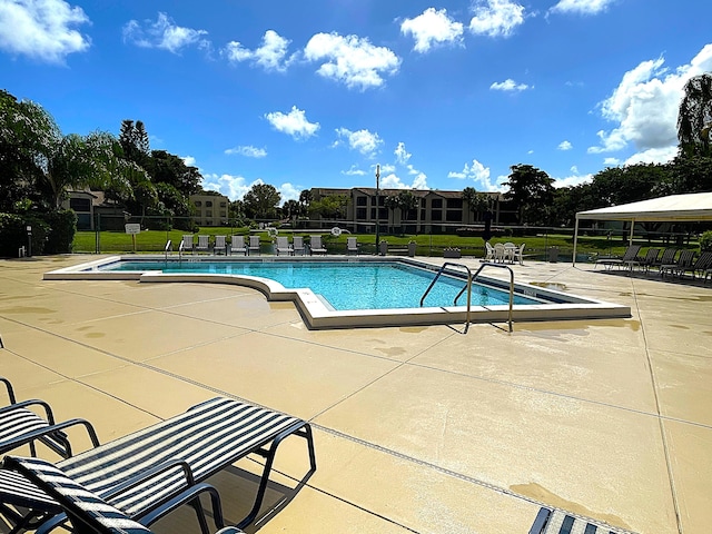 view of pool with a patio area and a lawn