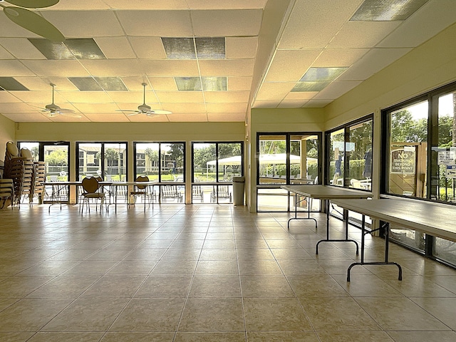 sunroom with a paneled ceiling, ceiling fan, and a wealth of natural light