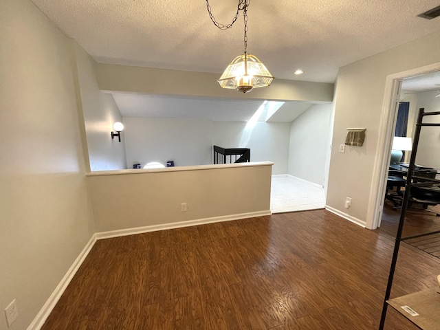 empty room with a textured ceiling and dark wood-type flooring