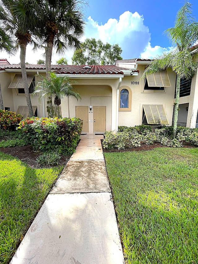 mediterranean / spanish-style home with a front yard