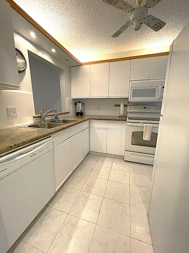 kitchen featuring white appliances, white cabinetry, light tile patterned floors, and sink