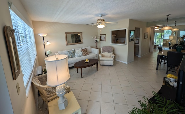 living room with a textured ceiling, light tile patterned flooring, and ceiling fan