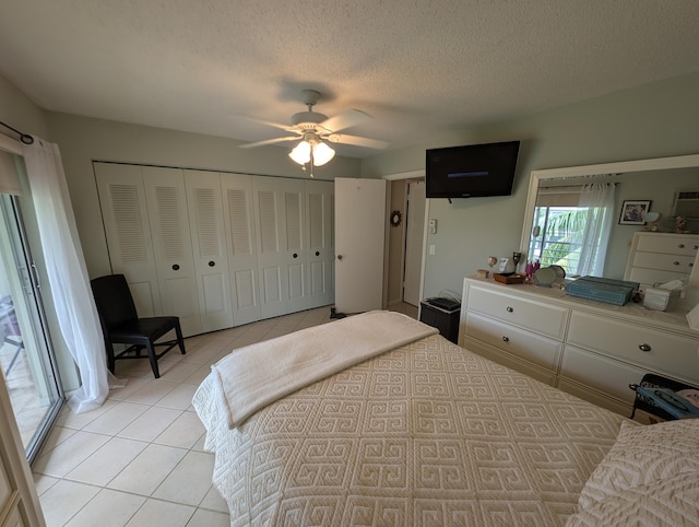 bedroom with light tile patterned flooring, a textured ceiling, a closet, and ceiling fan