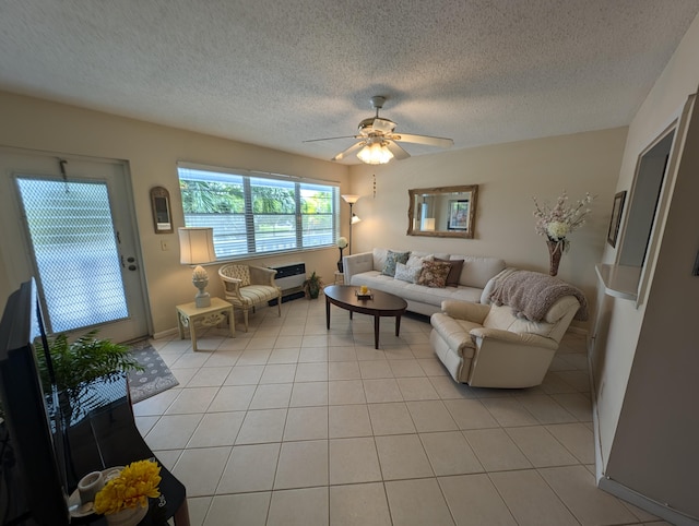 living room with a textured ceiling, light tile patterned floors, and ceiling fan