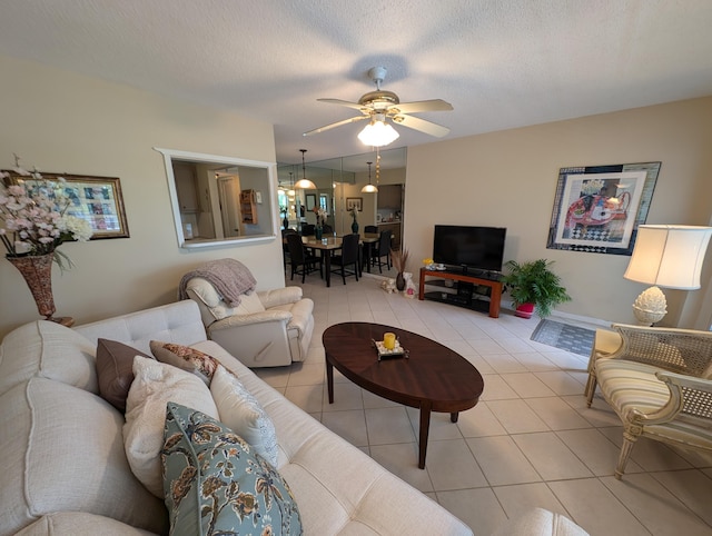 living room with a textured ceiling, light tile patterned flooring, and ceiling fan