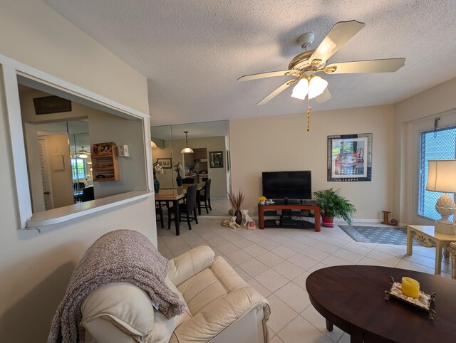 tiled living room with a textured ceiling and ceiling fan