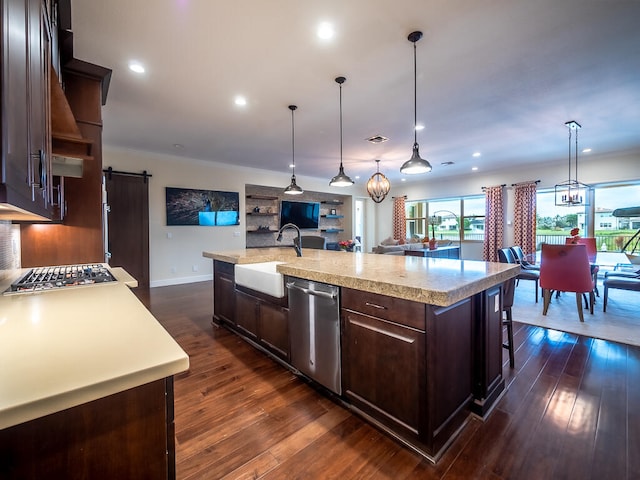 kitchen with a center island with sink, stainless steel dishwasher, a barn door, and dark brown cabinets