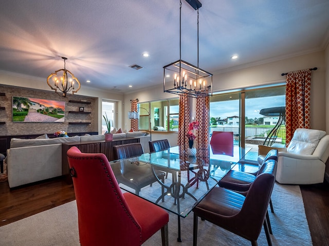 dining room with crown molding, wood-type flooring, and an inviting chandelier