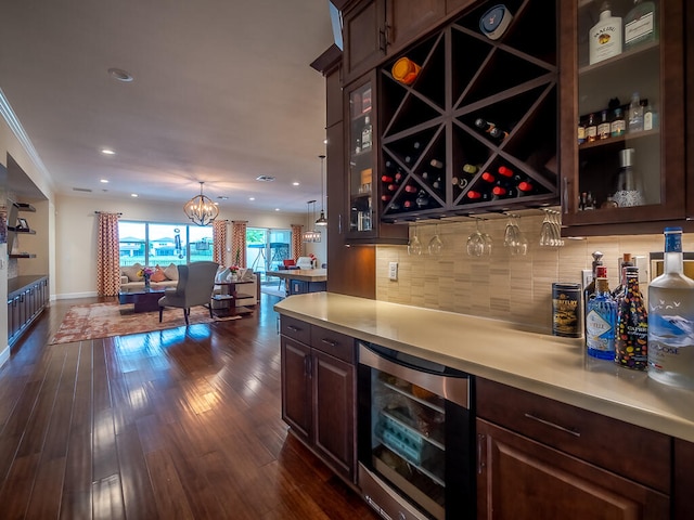 bar featuring decorative backsplash, dark brown cabinets, wine cooler, a notable chandelier, and dark hardwood / wood-style flooring