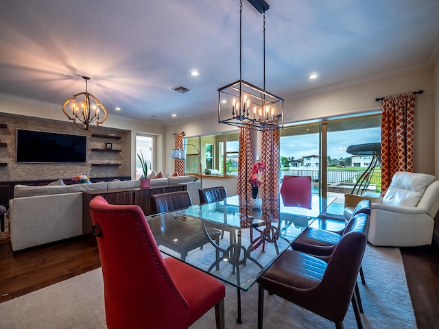 dining room featuring an inviting chandelier, ornamental molding, wood-type flooring, and plenty of natural light