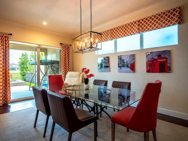 dining space with ornamental molding, a wealth of natural light, a chandelier, and hardwood / wood-style floors