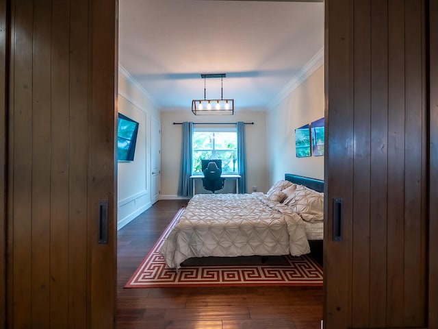 bedroom featuring crown molding and dark hardwood / wood-style floors