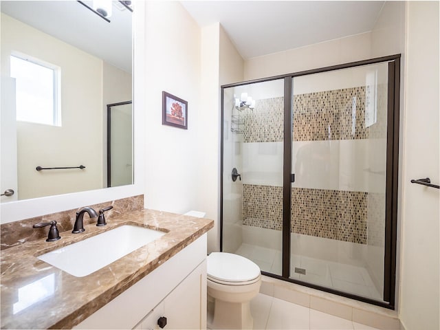 bathroom with vanity, toilet, tile patterned floors, and a shower with door