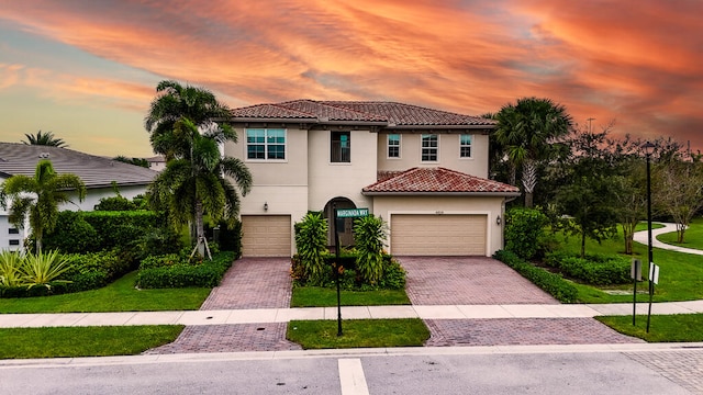 mediterranean / spanish-style house with a garage and a lawn