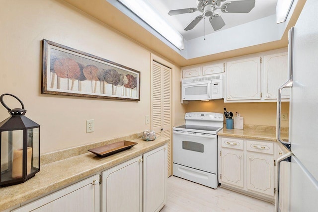 kitchen featuring white cabinets, ceiling fan, light wood-type flooring, and white appliances