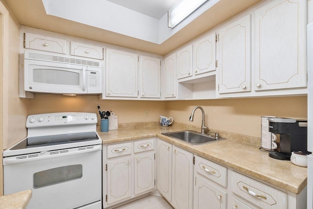 kitchen with white cabinets, sink, and white appliances