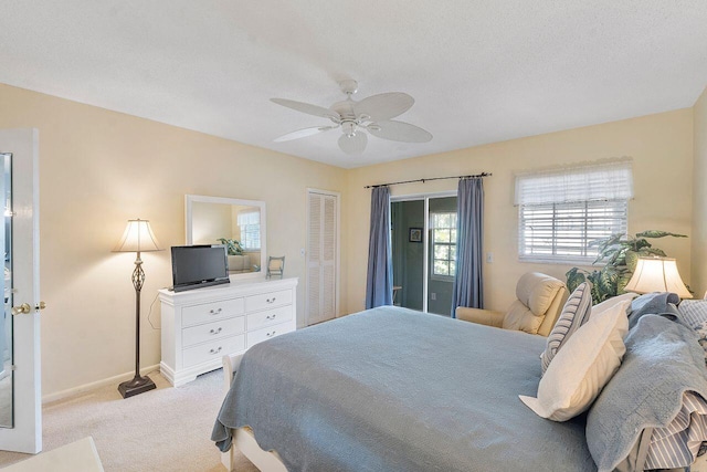 carpeted bedroom featuring ceiling fan and a textured ceiling