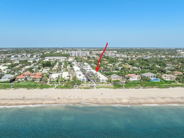 birds eye view of property featuring a water view and a beach view