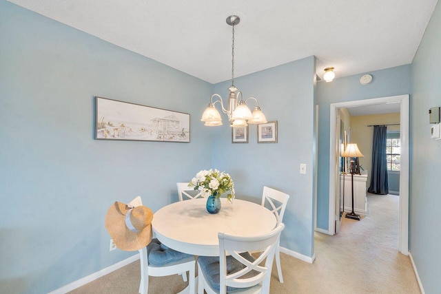 dining space with an inviting chandelier and light colored carpet