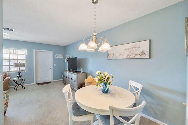 dining space featuring a chandelier and light carpet