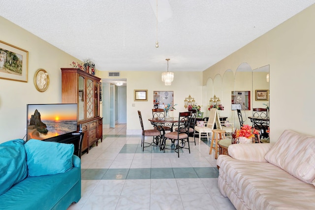 tiled living room with a chandelier and a textured ceiling