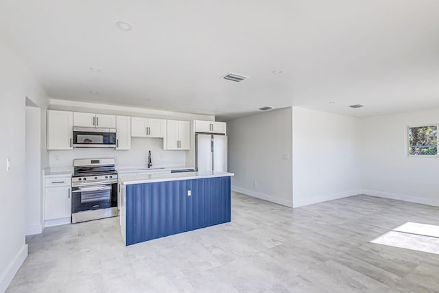 kitchen featuring a kitchen island, white cabinetry, sink, and appliances with stainless steel finishes