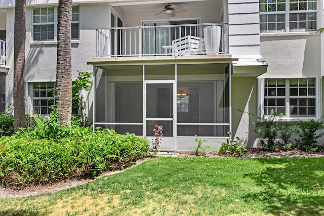 exterior space with a lawn, a sunroom, and a balcony