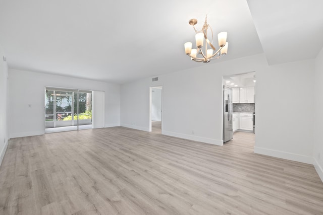 interior space with a notable chandelier and light wood-type flooring