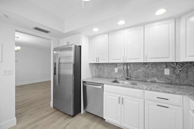 kitchen with white cabinetry, stainless steel appliances, and light wood-type flooring