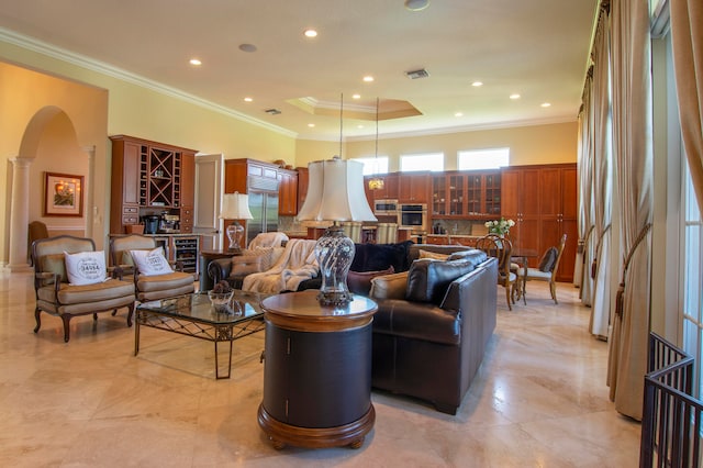 living room with ornamental molding and decorative columns