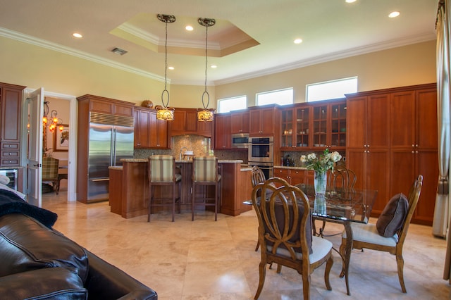 dining area featuring ornamental molding, sink, and a tray ceiling