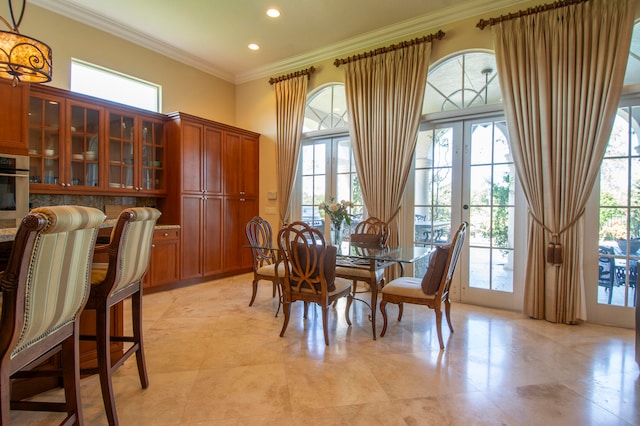 dining room with french doors, a healthy amount of sunlight, and crown molding