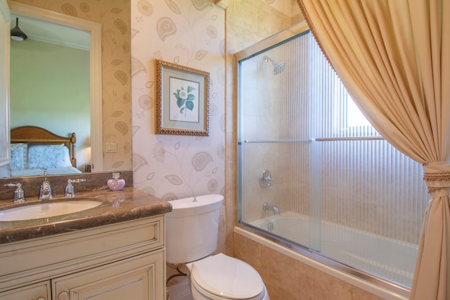 full bathroom featuring bath / shower combo with glass door, toilet, and vanity