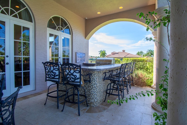 view of patio with french doors, area for grilling, and exterior bar