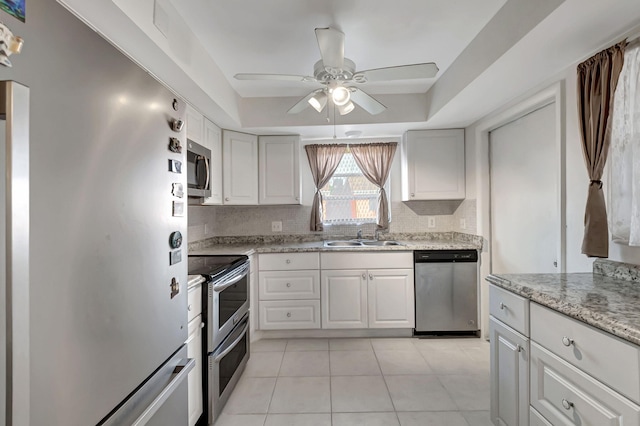 kitchen featuring tasteful backsplash, appliances with stainless steel finishes, light tile patterned flooring, and white cabinets