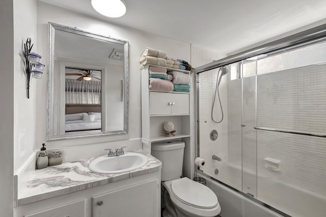 full bathroom featuring vanity, toilet, shower / bath combination with glass door, and ceiling fan