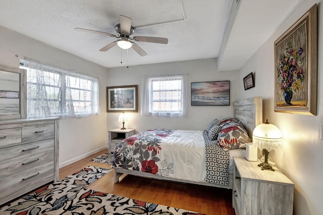 bedroom featuring a textured ceiling, wood-type flooring, and ceiling fan