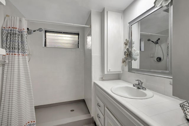 bathroom featuring vanity, a shower with curtain, and tasteful backsplash