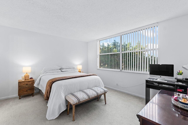 bedroom with light carpet and a textured ceiling