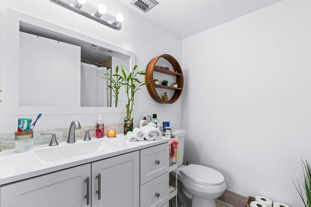 bathroom featuring toilet and vanity