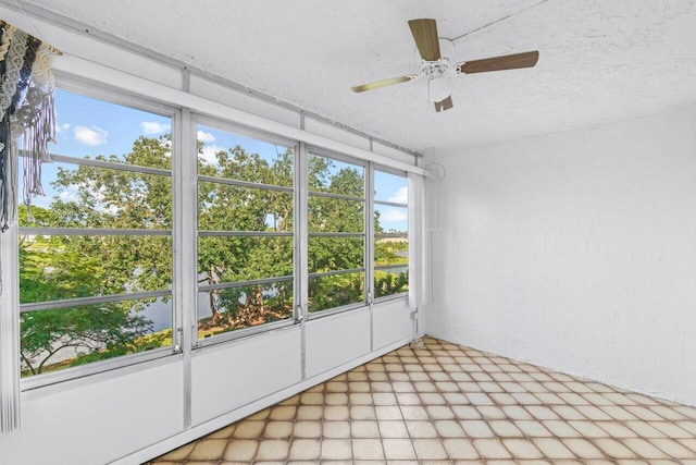 unfurnished sunroom featuring ceiling fan and plenty of natural light