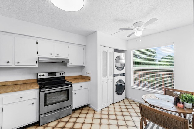 kitchen featuring stainless steel electric range, white cabinetry, stacked washer / dryer, a textured ceiling, and ceiling fan