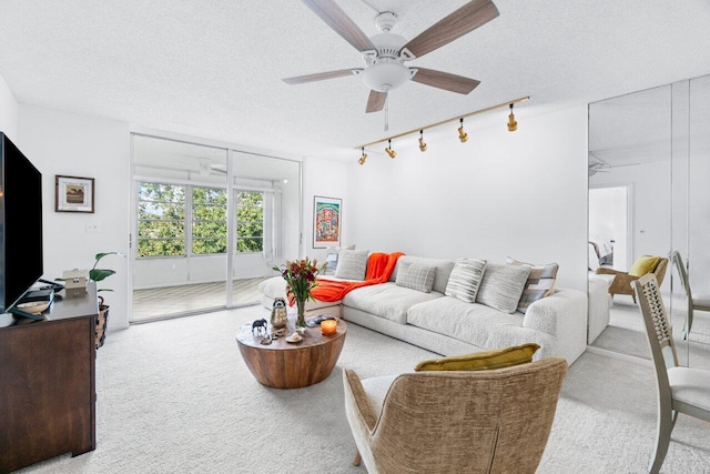 carpeted living room with a textured ceiling and ceiling fan